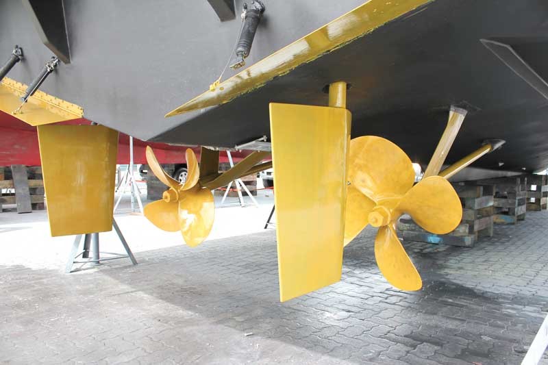Dual boat engine props being inspected and prepped with foul release coating.