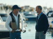 A boat owner and broker agent engage in a deep discussion by the dockside